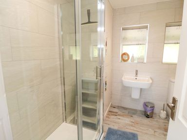 A bathroom featuring a shower, sink, and toilet at Beach House