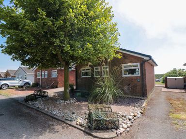 A house with a tree and stones in front at Beach House in 