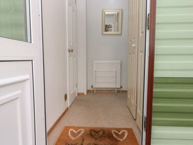 A hallway with a mirror and radiator at Static Caravan