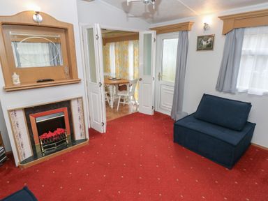 A living room with a sofa and a fireplace at Static Caravan