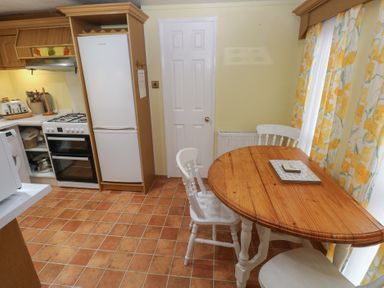A kitchen with a table and chairs at Static Caravan