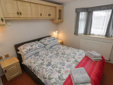 A bedroom with a bed and light fixtures at Static Caravan in 