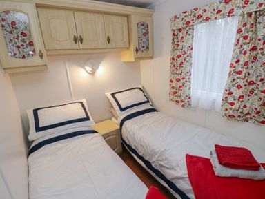 A bedroom with two beds and a wall cabinet at Static Caravan in 
