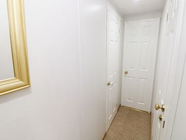 A hallway with doors and a mirror at the Static Caravan