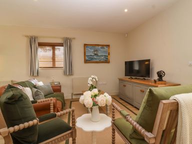 A living room with a tv and sofa at The Annex in Burford