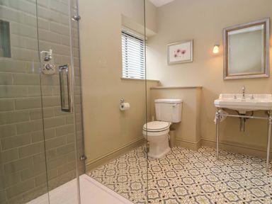 A bathroom with a shower, toilet, and sink at The Annex in Burford