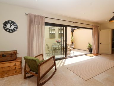 A room with a rocking chair and sliding doors to an outdoor area at The Annex in Burford