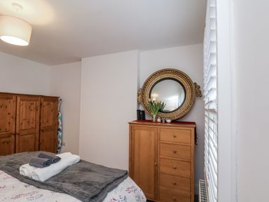 A bedroom with a bed and a wardrobe at 1 Castle Terrace in Thirsk