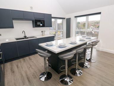 A kitchen with bar stools and countertop at Cottage 1 in Laugharne