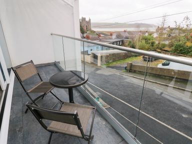 A balcony with chairs and a table at Cottage 1 in Laugharne