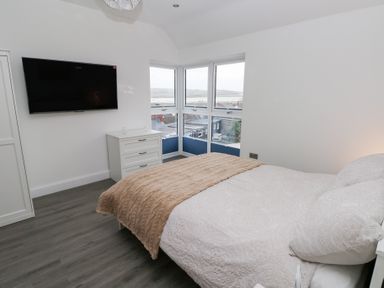 A bedroom with a bed and television at Cottage 1 in Laugharne