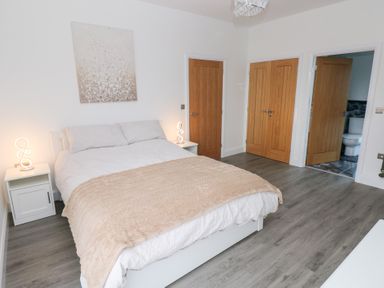 A bedroom with a bed and bedside tables at Cottage 1 in Laugharne