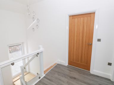 A hallway with a door and window at Cottage 1 in Laugharne
