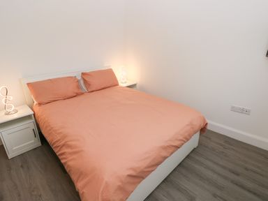 A bedroom with a bed and nightstands at Cottage 1 in Laugharne
