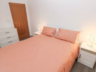 A bedroom with a bed and nightstands at Cottage 1 in Laugharne