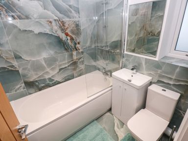 A bathroom with bathtub, toilet, and sink at Cottage 1 in Laugharne