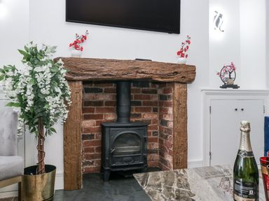 A fireplace with a stove and wooden mantel in a living room at Aspen Boutique