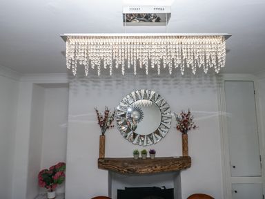 A living room with a chandelier and mirror at Aspen Boutique
