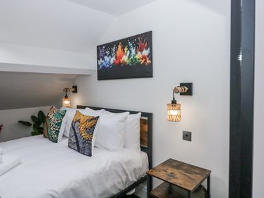 A bedroom with a bed and wall art at Aspen Boutique