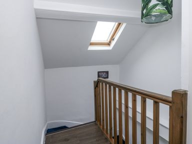 A staircase with a wooden railing and skylight at Aspen Boutique
