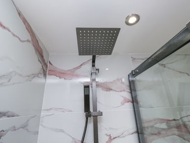 A shower with a rain showerhead and handheld shower at Aspen Boutique
