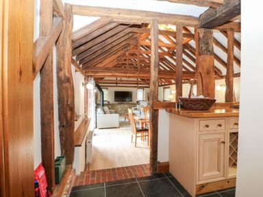 A living room with beams and a dining area at WEST LODGE Ashford