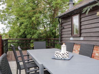 An outdoor dining table with chairs at WEST LODGE in Ashford