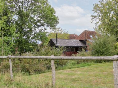 A house surrounded by trees and grass at WEST LODGE in Ashford