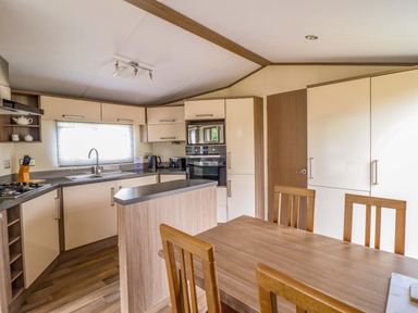 A kitchen with a sink and stove at Beach Retreat E19 Dyffryn Seaside Estate Dyffryn Ardudwy