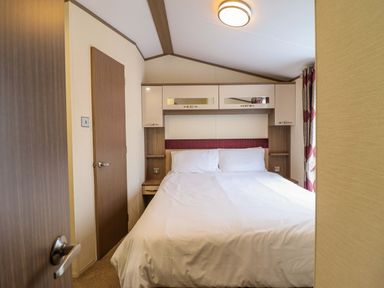 A bedroom with a bed and storage units at Beach Retreat E19 Dyffryn Seaside Estate Dyffryn Ardudwy