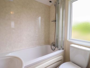 A bathroom featuring a bathtub and toilet at Beach Retreat E19 Dyffryn Seaside Estate Dyffryn Ardudwy