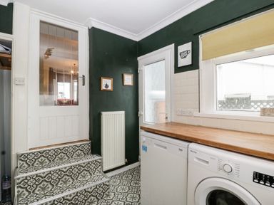 A laundry room with washing machine and countertop at Gavin and Stacey House in Barry