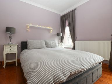A bedroom with a bed and nightstands at Gavin and Stacey House in Barry