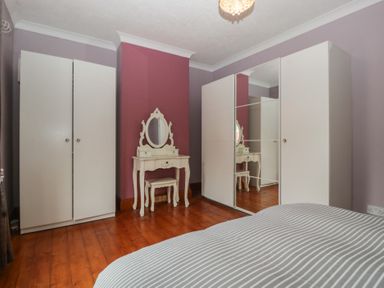 A bedroom with wardrobe and dressing table at Gavin and Stacey House in Barry