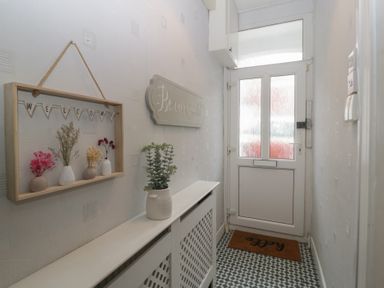A hallway with a welcome sign and vases at Gavin and Stacey House in Barry