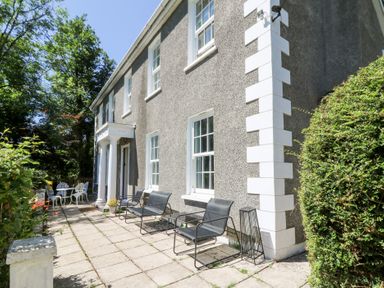 A house exterior with seating area and table at Ty Caredig in Swansea