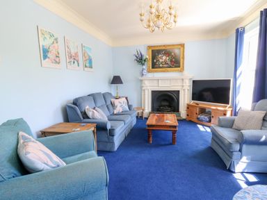 A living room with sofas and a coffee table at Ty Caredig in Swansea