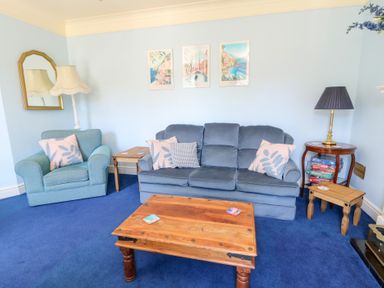 A living room with a sofa and chair at Ty Caredig in Swansea