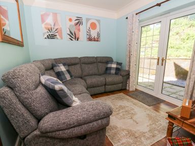 A living room with a sofa and artwork at Ty Caredig in Swansea