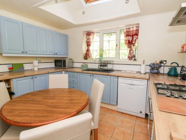 A kitchen with cabinets and a table at Ty Caredig in Swansea