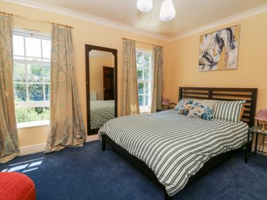 A bedroom with a bed and mirror at Ty Caredig in Swansea