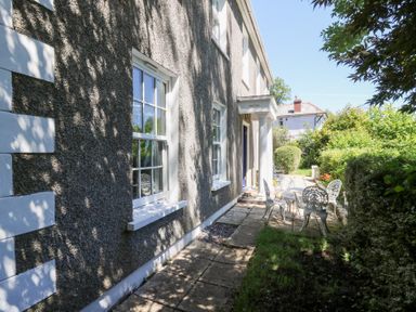 A garden with a seating area at Ty Caredig in Swansea