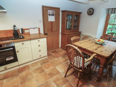 A kitchen with a table and chairs at 1 Rowes Cottages Penzance
