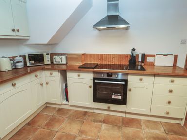 A kitchen with a cooktop and oven at 1 Rowes Cottages in Penzance