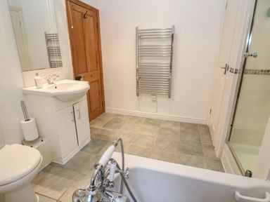 A bathroom with a sink and bathtub at 1 Rowes Cottages in Penzance