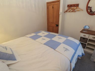 A bedroom with a bed and storage unit at 1 Rowes Cottages in Penzance