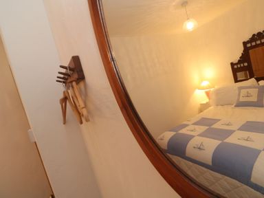 A bedroom with a bed and lamp at 1 Rowes Cottages in Penzance