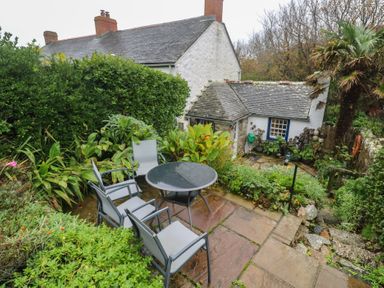 A garden with chairs and a table at 1 Rowes Cottages in Penzance
