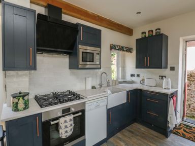A kitchen with appliances and cabinets at 13 School Road in Newton Abbot