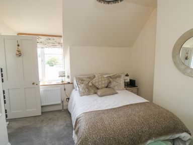 A bedroom with a bed and window at 13 School Road in Newton Abbot